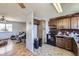 Functional kitchen featuring wood cabinetry, a brick accent wall, and access to the living room at 10932 W 107Th Ave, Broomfield, CO 80021