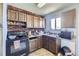 Functional kitchen featuring wood cabinetry, a brick accent wall, and ample counter space at 10932 W 107Th Ave, Broomfield, CO 80021