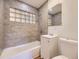 Modern bathroom with gray tiled shower and flooring, complemented by a clean white vanity and fixtures at 1325 Lima St, Aurora, CO 80010
