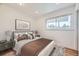 Staged bedroom features a decorative print, nightstand, and large window views at 1325 Lima St, Aurora, CO 80010
