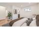 Bedroom features an ensuite bath, plant, decorative print, and a window at 1325 Lima St, Aurora, CO 80010