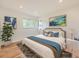 Staged bedroom features a decorative rug, houseplant, window views, and a beautifully made bed at 1325 Lima St, Aurora, CO 80010