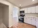 Bright kitchen featuring stainless steel appliances, white cabinets, and ample countertop space for meal preparation at 1325 Lima St, Aurora, CO 80010