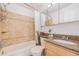 Well-lit bathroom with a shower-tub combo, tiled walls, and a wood vanity with granite countertops at 1885 S Quebec Way # C15, Denver, CO 80231