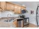 Charming kitchen featuring stainless steel appliances, double sink, granite countertops, and light wood cabinetry at 1885 S Quebec Way # C15, Denver, CO 80231