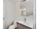 Bathroom featuring a white toilet, gray vanity, and large mirror at 3420 Tennyson St # 105, Denver, CO 80212