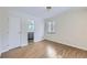 Bright bedroom with light wood floors, window, and door to bath at 3420 Tennyson St # 105, Denver, CO 80212