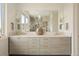 Bathroom featuring a double vanity, elegant lighting, and a large mirror at 6196 Oxford Peak Ln, Castle Rock, CO 80108