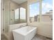 Spa-like bathroom with a soaking tub, glass-enclosed shower, and a large window at 6196 Oxford Peak Ln, Castle Rock, CO 80108