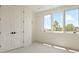 Bright bedroom featuring ample natural light from a large window and a spacious closet with white paneled doors at 6196 Oxford Peak Ln, Castle Rock, CO 80108