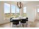 Bright dining area features large windows, modern lighting fixture, and neutral color palette at 6196 Oxford Peak Ln, Castle Rock, CO 80108