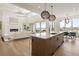 Open concept kitchen and living room with modern lighting, fireplace, and large sliding glass doors at 6196 Oxford Peak Ln, Castle Rock, CO 80108