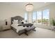 Bright bedroom featuring a large window, plush bedding, and stylish decor elements at 6196 Oxford Peak Ln, Castle Rock, CO 80108