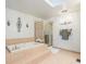 Bathroom showcasing a tiled soaking tub, a glass-enclosed shower, decorative sconces, and neutral paint at 10000 E Yale Ave # 7, Denver, CO 80231
