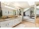 Bright bathroom featuring double sinks, granite countertops, a soaking tub, and an open view into the bedroom at 10000 E Yale Ave # 7, Denver, CO 80231