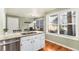 Bright kitchen features a stainless steel dishwasher and island sink, granite countertop, and hardwood floors at 10000 E Yale Ave # 7, Denver, CO 80231