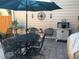 Cozy patio area with an umbrella, dining set, plants, and decorative wall hangings at 10000 E Yale Ave # 7, Denver, CO 80231