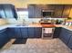 Well-lit kitchen features stainless steel appliances, dark cabinetry, and a practical double sink at 2874 Rose Hill St, Strasburg, CO 80136