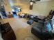 Inviting living room with a gray couch, dining area, ceiling fan and neutral-toned carpet at 2874 Rose Hill St, Strasburg, CO 80136