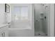 Bright bathroom featuring a shower with glass door and soaking tub beneath a window offering natural light at 2954 E 108Th Dr, Northglenn, CO 80233