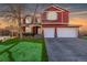 Charming two-story home with a well-maintained lawn and a spacious two car garage during sunset at 2954 E 108Th Dr, Northglenn, CO 80233