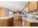 Bright kitchen featuring wood cabinets, modern appliances, ample counter space, and stylish backsplash at 2954 E 108Th Dr, Northglenn, CO 80233