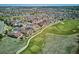 Expansive aerial view of a golf course community featuring well-maintained homes and green fairways under a clear sky at 23312 E Chestnut Pl, Aurora, CO 80016