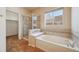 Bathroom featuring a soaking tub, glass-enclosed shower and large window at 23312 E Chestnut Pl, Aurora, CO 80016