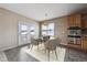 Bright dining area features a stylish round table and chairs, with access to a patio and views of a snowy landscape at 23312 E Chestnut Pl, Aurora, CO 80016