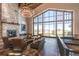 Stunning living room featuring a stone fireplace, hardwood floors, high ceilings, and large windows with neighborhood views at 23312 E Chestnut Pl, Aurora, CO 80016