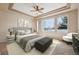 Comfortable main bedroom with a tray ceiling, large windows, and modern furnishings at 23312 E Chestnut Pl, Aurora, CO 80016