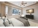This main bedroom features tray ceilings, a ceiling fan, and large windows with a snowy view at 23312 E Chestnut Pl, Aurora, CO 80016