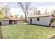 Wide shot of the large backyard area with green grass and two outbuildings at 4209 S Bannock St, Englewood, CO 80110