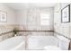 Bathroom featuring a bathtub, shower, and toilet with neutral tile and a decorative border at 4209 S Bannock St, Englewood, CO 80110