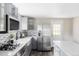 Bright kitchen features stainless steel appliances, modern gray cabinets, and mosaic backsplash at 4209 S Bannock St, Englewood, CO 80110