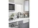 This well-lit kitchen shows a farmhouse sink, gray cabinets, and stylish backsplash at 4209 S Bannock St, Englewood, CO 80110