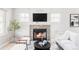 Bright living room with stone fireplace, large TV, and modern, neutral-toned furniture at 4209 S Bannock St, Englewood, CO 80110