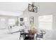 Open concept living space with dining table and view to the kitchen and stone fireplace at 4209 S Bannock St, Englewood, CO 80110