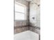 Shower featuring a neutral tile surround and a window for natural light at 4209 S Bannock St, Englewood, CO 80110