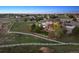 Aerial view of a home with a spacious lot, white fence, lush greenery, and large patio at 14953 Akron Ct, Brighton, CO 80602