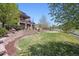Expansive backyard with tiered landscaping, retaining walls, grassy areas, and upper deck at 14953 Akron Ct, Brighton, CO 80602