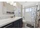 This bathroom features a white vanity, a tub and shower combination, and patterned shower curtain for added privacy at 14953 Akron Ct, Brighton, CO 80602