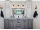 This bathroom has a double vanity with grey cabinets, white countertops, and unique globe lighting above the mirror at 14953 Akron Ct, Brighton, CO 80602