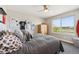 This bedroom has a queen-sized bed, a wooden dresser, and a window with scenic views of the outdoors at 14953 Akron Ct, Brighton, CO 80602