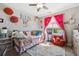 This bedroom has a cozy daybed with throw pillows and a colorful window with a view of the outdoors at 14953 Akron Ct, Brighton, CO 80602