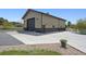 Exterior shot of a large gray and brown barn or garage with a full concrete parking pad and a well manicured lawn at 14953 Akron Ct, Brighton, CO 80602