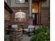 Inviting front porch area with a fire pit, seating, and brick accents at 14953 Akron Ct, Brighton, CO 80602