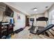 This home gym features multiple machines, free weights, a television, and rubber flooring at 14953 Akron Ct, Brighton, CO 80602