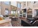 Spacious living room featuring a stone fireplace, built-ins, and large windows at 14953 Akron Ct, Brighton, CO 80602