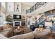 Grand living room showcasing a stone fireplace, high ceilings, and stylish decor at 14953 Akron Ct, Brighton, CO 80602
